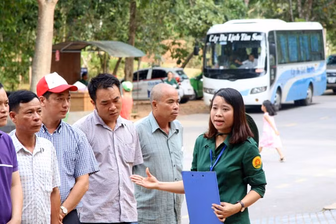 Chị Lương Thị Thủy đang thuyết minh về di tích hố bom cho đoàn khách tham quan.Ảnh: V.B.