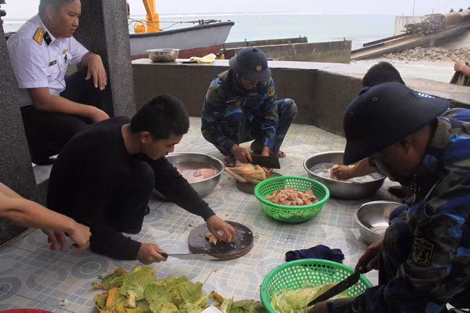 Các chiến sĩ đảo Tốc Tan A làm cơm trong ngày mưa bão. Ảnh: Trường Phong.