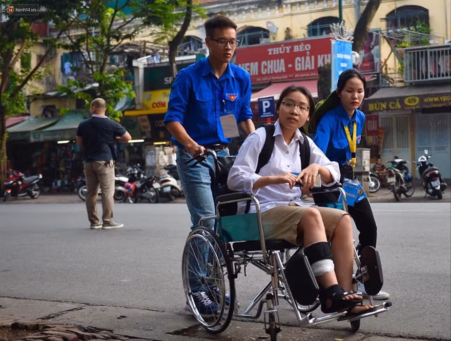 Các tình nguyện viên hỗ trợ thí sinh Nguyễn Thị Thúy Hà bị tai nạn giao thông vào điểm thi trường THPT Việt Đức Ảnh: CTV