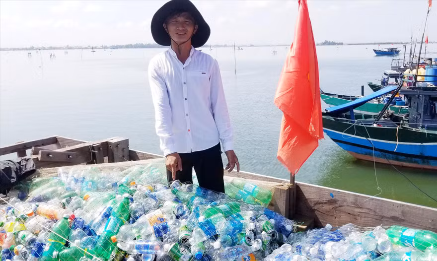 “Gã khùng” Trần Văn Cường với đống “chiến lợi phẩm” gom nhặt được sau một chuyến đi biển Ảnh: H.Thương