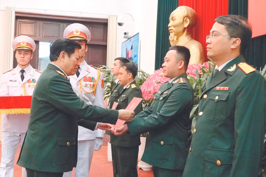Đại tướng Ngô Xuân Lịch trao quyết định thăng quân hàm trước niên hạn, tuyển dụng quân nhân chuyên nghiệp cho 4 GMTTB toàn quân, sáng 17/3. Ảnh: Nguyễn Minh