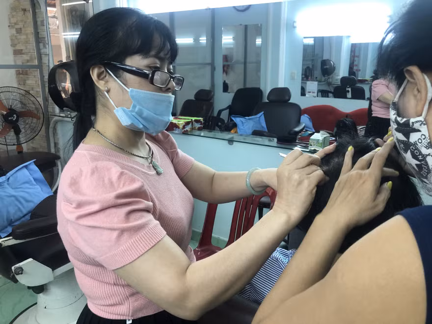 Chị Bùi Thị Tuyết, chủ tiệm Nhổ tóc bạc Tuyết (Bàn Cờ, quận 3, TPHCM) hành nghề “bới đen, tìm trắng” luôn có nguồn khách ruột ổn định Ảnh: U.P 