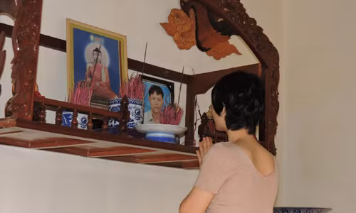 Bà Tâm thắp nén nhang cho người chồng quá cố