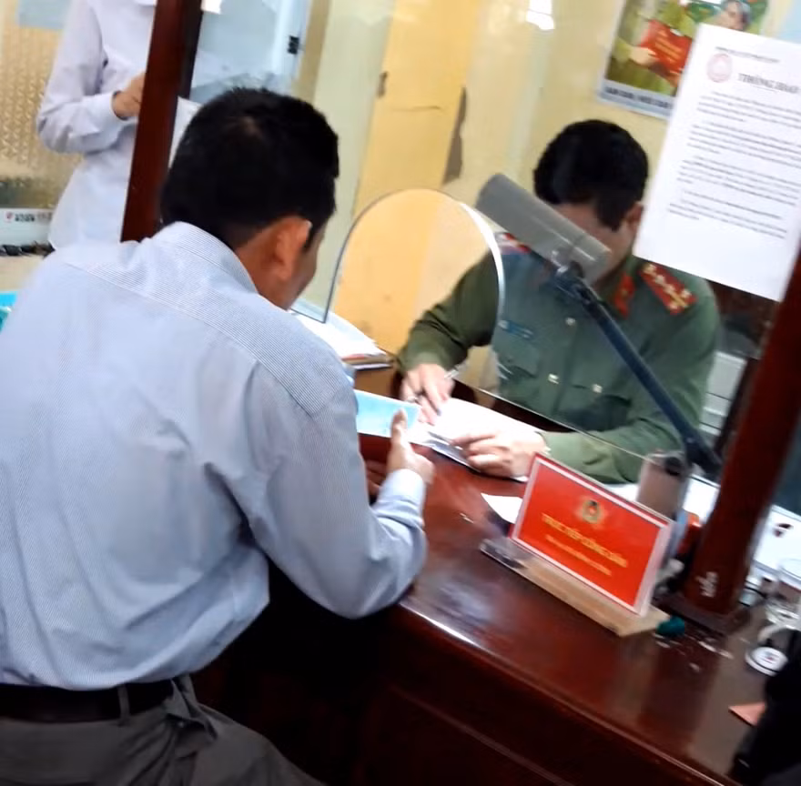 Cán bộ phòng QLXNC Hải Dương "báo giá" người dân làm hộ chiếu nhanh.ảnh: DH