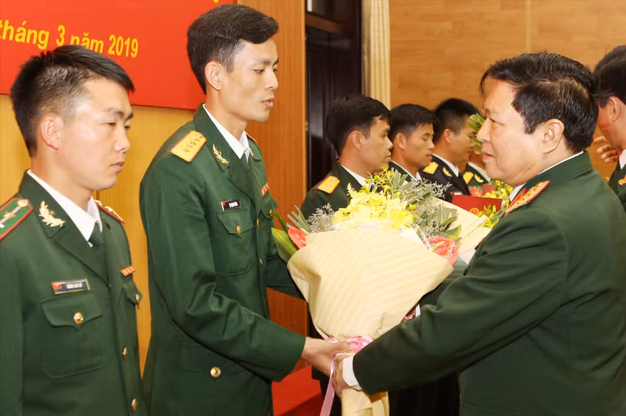 Đại tướng Ngô Xuân Lịch, Bộ trưởng Bộ Quốc phòng tặng hoa chúc mừng đại úy Tạ Mạnh Hùng và các Gương mặt trẻ tiêu biểu toàn quân 2018. ẢNH: NGUYỄN MINH