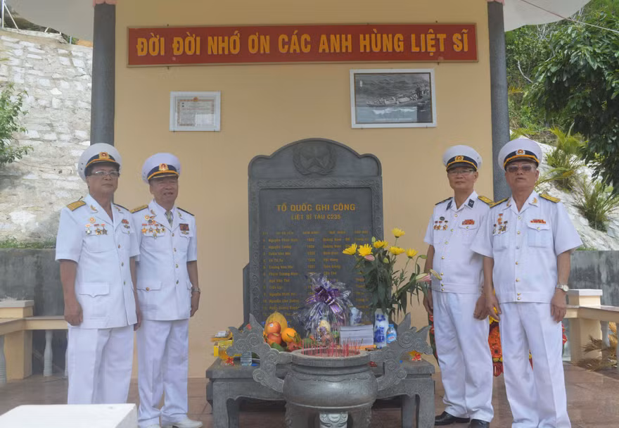 Các CCB tàu C235 Lê Duy Mai, Hà Minh Thật, Lâm Quang Tuyến, Nguyễn Hồng Phong trước tấm bia ghi danh các đồng đội liệt sĩ tàu C235 tại Khu di tích lịch sử Quốc gia Hòn Hèo. Ảnh: KIẾN NGHĨA 