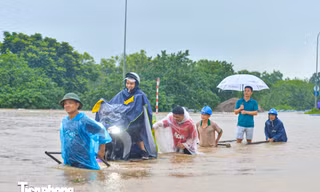 Ùn dài hàng km trên Đại lộ Thăng Long, dịch vụ kéo xe qua khu vực ngập lụt 'đắt khách'
