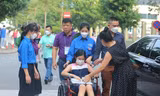 Học sinh ngồi xe lăn, có bác sĩ đi kèm đến phòng thi xét tuyển vào lớp 6