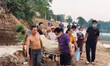 Người dân đưa thi thể bà Trang lên bờ. Ảnh: H. N