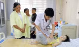 Bác sĩ Trung tâm Y tế huyện Cẩm Khê thăm khám cho cháu Nguyễn Khánh Ly, 3 tuổi, ở khu 4 xã Hương Lung. Ảnh: Trung Kiên - TTXVN