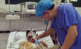 PGS.TS Nguyễn Hữu Ước kiểm tra sức khỏe của bệnh nhân B. sau khi đặt stent graft. Ảnh BV Việt - Đức cung cấp