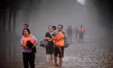 Người dân Trác Châu sơ tán khỏi vùng lũ ngày 1/8. (Ảnh: Reuters)
