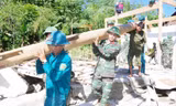 Cán bộ, chiến sỹ Ban CHQS huyện Tương Dương giúp gia đình ông Lô Văn Tiến ở bản Vẽ di dời nhà bị sập do mưa lũ. Ảnh: P.Q