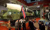 Chủ tịch Triều Tiên Kim Jong Un phát biểu với một số quan chức khi đứng cạnh các vũ khí được đưa ra triển lãm hôm 12/10. (Ảnh: KCNA)