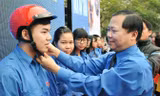 Anh Nguyễn Phi Long - Bí thư T.Ư Đoàn, Chủ tịch T.Ư Hội LHTN Việt Nam tặng mũ bảo hiểm cho ĐVTN tại lễ phát động. Ảnh: Xuân Tùng