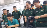 Đại biểu dự hội nghị tham quan dây chuyền sản xuất thanh niên tại Tổng Cty 28, Tổng cục Hậu cần, sáng 3/11. Ảnh: Nguyễn Minh