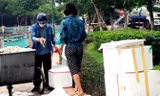 Hình ảnh đôi nam nữ lấy cá chết ở hồ Tây cho vào thùng xốp. Ảnh người dân cung cấp