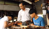 Ông Nguyễn Văn Tiếp hướng dẫn chạm khắc cho thanh niên mới học nghề. Ảnh: Thanh Trần