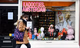 Một người phụ nữ đeo khẩu trang đi bộ ở Amsterdam (Hà Lan). Ảnh: Reuters