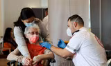 Một cụ bà người Israel đi tiêm vắc-xin. Ảnh: Reuters