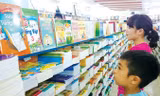Phụ huynh cùng con lựa chọn mua sách giáo khoa tại một hiệu sách ở Hà Nội. Ảnh: Ngọc Châu.