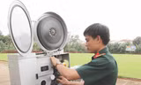 Anh Trương Huy Thái ráp phim vào máy, chuẩn bị trước cho buổi chiếu phim.