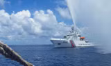 Tàu hải cảnh Trung Quốc phun vòi rồng vào tàu cá Philippines gần bãi cạn Scarborough trên biển Đông. Ảnh: AP.