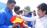 Anh Trần Thanh Lâm, Phó tổng biên tập báo Tiền Phong trao cờ cho anh Phải. ảnh: PV