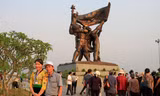 Chị Lò Thị Toản chụp ảnh lưu niệm với khách du lịch bên tượng đài chiến thắng Điện Biên Phủ