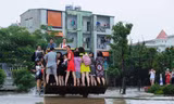 Người dân phải dùng xe xúc để đi qua các điểm ngập sâu.