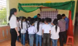 Cô và các bạn trong lớp 4C, trường Tiểu học Diễn Quảng đưa giấy khen và phần thưởng đến cho em Trần Việt Hưng.