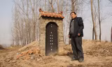 Ông Li Fucai đứng cạnh ngôi mộ từng chôn cất thi thể cha và mẹ ông. Ảnh: The Telegraph 