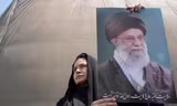 Một người dân giương cao ảnh chân dung Đại giáo chủ Iran trong cuộc biểu tình tại Tehran ngày 13/6. (Ảnh: AP)