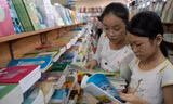 Học sinh tiểu học lựa chọn sách giáo khoa tại một cửa hàng sách trên đường Lý Thường Kiệt (Hà Nội). Ảnh: Hồng Vĩnh