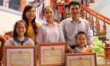 Gia đình anh Thành, chị Yến với những tấm giấy khen của Công an tỉnh Bắc Giang.