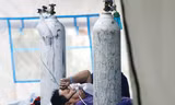 Một bệnh nhân COVID-19 nằm trong lều cấp cứu tại một bệnh viện ở Jakarta (Indonesia). Ảnh: AP 