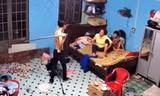 N. dùng cây lau nhà đánh mẹ. Ảnh cắt từ clip.