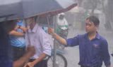 Tình nguyện viên dầm mưa hỗ trợ thí sinh 