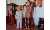 Cụ Một bên cạnh con dâu và chắt nội. Cụ có hơn 40 cháu, chắt. Ảnh: Đoàn Nguyên.