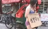Cô Wang Ni với tấm biển "tôi bán cơ thể mình" trên cổ (Ảnh: Mirror)
