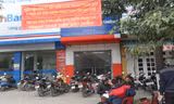 Đại diện Công ty CP Hoàng Thịnh treo băng rôn và ngồi trước cửa yêu cầu công ty Bảo hiểm Xuân Thành Thanh Hóa thanh toán tiền bảo hiểm. Ảnh: Phạm Nhài.
