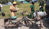 Cảnh sát giao thông lập biên bản xử lý một trường hợp xe máy “cà tàng”. Ảnh Việt Văn.