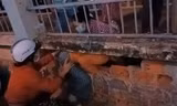 Các phụ nữ đang chui lỗ tường rào thoát ra bệnh viện, đêm 1/7. Ảnh: Cắt từ video người dân cung cấp/VnExpress