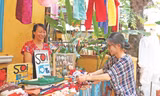 Chị Trương Nguyễn Hoài An, người sáng lập Chợ phiên thủ công (bên phải) hỗ trợ các cư dân của xóm bày biện, sắp xếp hàng hóa Ảnh: Giang Thanh 