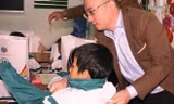 Ông Nguyễn Phan Huy Khôi, Giám đốc Đối ngoại, Tập đoàn Number 1 (Tân Hiệp Phát) mặc áo ấm cho một em nhỏ dân tộc Vân Kiều tại trường Tiểu học Trường Sơn, huyện Quảng Ninh.