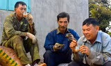 Những người nông dân tranh thủ uống cà phê lúc nghỉ giải lao.