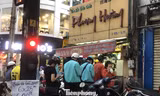 Tiệm trà sữa bán mang về rất đông người xếp hàng chờ mua đứng rất gần nhau