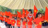 Năm học 2021-2022, học sinh ở nhiều địa phương sẽ dự lễ khai giảng trực tuyến, không rực rỡ cờ hoa như thế này, nhưng vẫn ấm áp. Ảnh: TTXVN