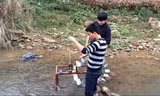 Hai "nhà phát minh" đang thử chạy thiết bị đưa nước lên cao không cần dùng điện tại một con suối.
