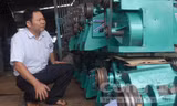 Nông dân Đặng Văn Bẩy bên Cơ sở Cơ khí Toàn Thắng do anh thành lập.